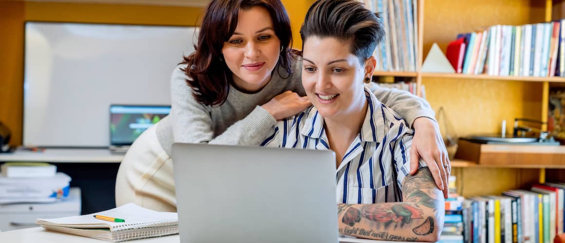 A couple looking at a laptop together, potentially engaging in activities such as browsing or working online as a team.