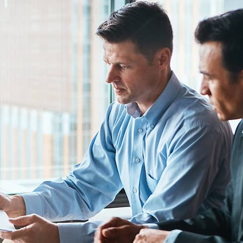 Two men going over paperwork together.