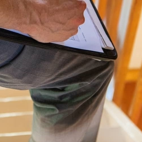 Close-up image of a pest inspection officer holding a clipboard.