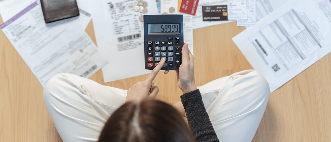 Woman using calculator on floor.