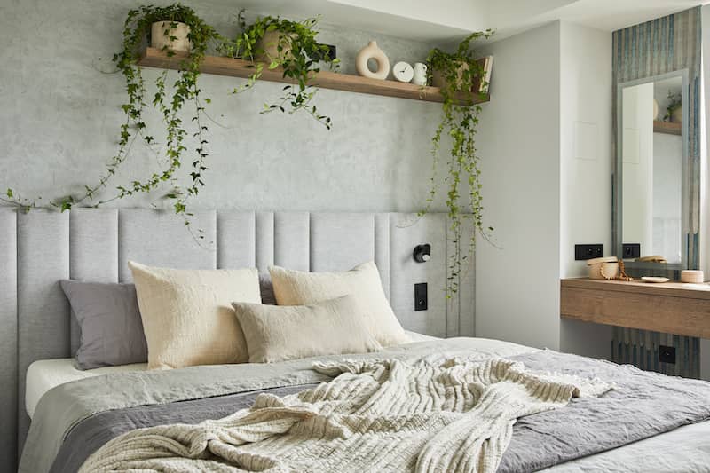 RHB Assets From IGX: A serene primary bedroom with greenery accents and cozy bedding.