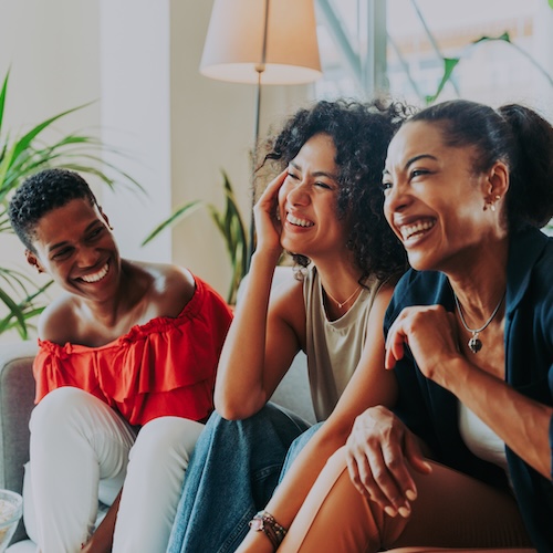 Group of three women talking and laughing.