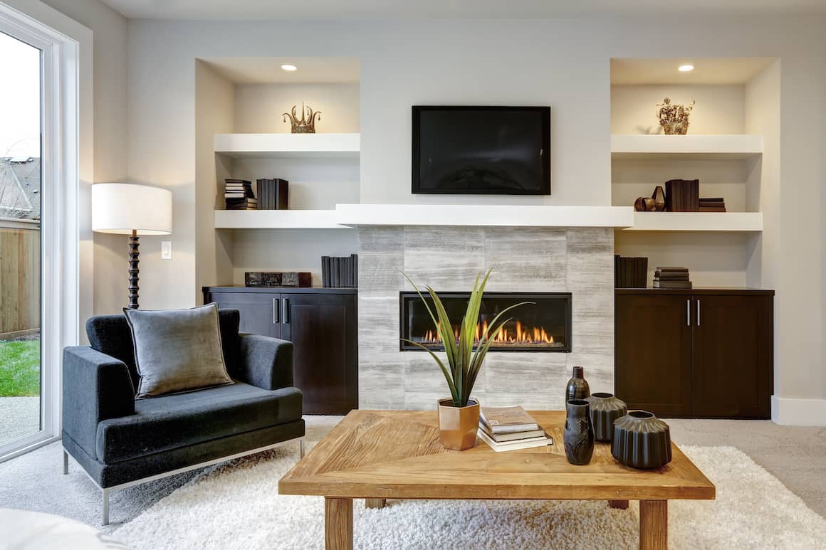 Modern living room with fireplace and plants.