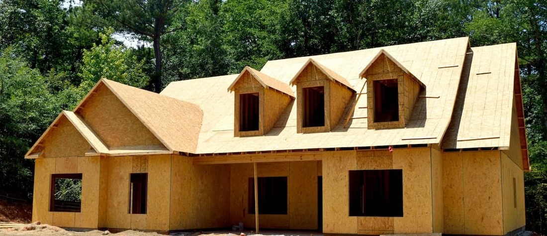 New home being constructed on wooded lot. 