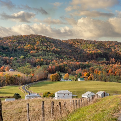 Rolling hills of rural Virginia with farms and the Appalachian mountains in the distance during a late fall afternoon.