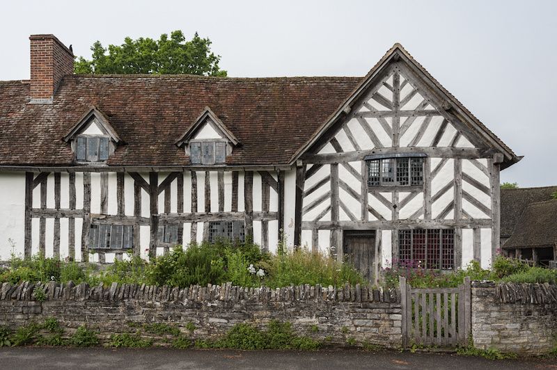 RHB Assets From IGX: A delerict Tudor-style house with brown wooden beams and a white stucco exterior.