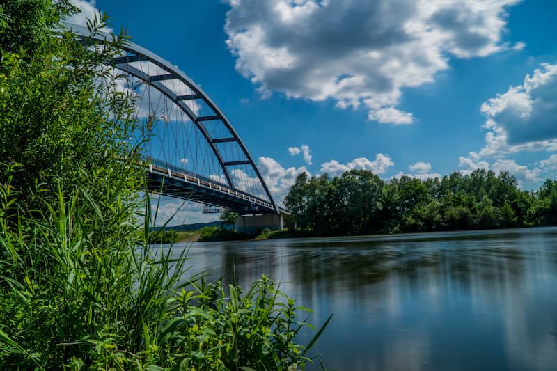 Small bridge over Missouri River in Leavenworth, Kansas surrounded by lush greenery.