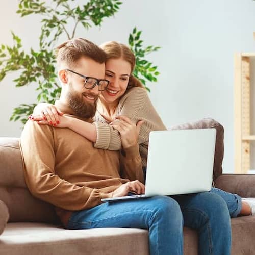 A couple working on a laptop together, potentially related to real estate or financial activities.