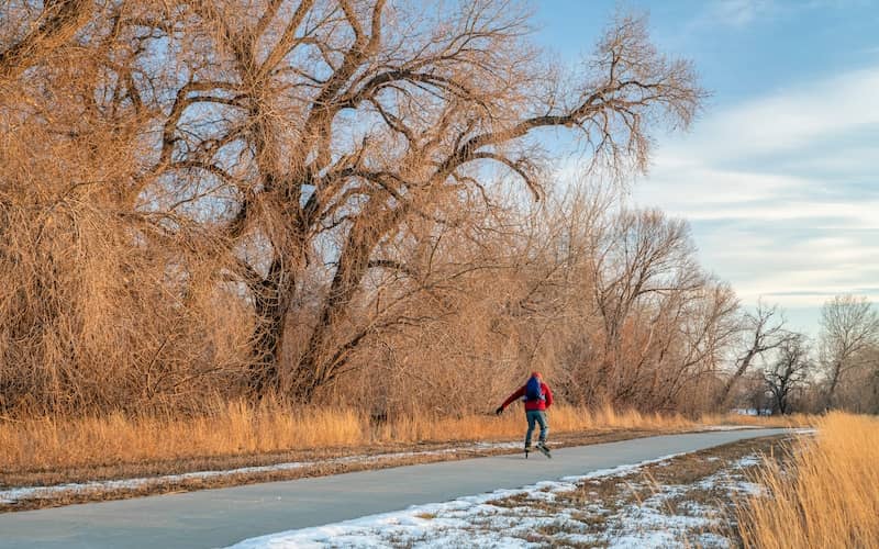 Inline skater on a paved trail in the fall along the Cache La Poudre River.