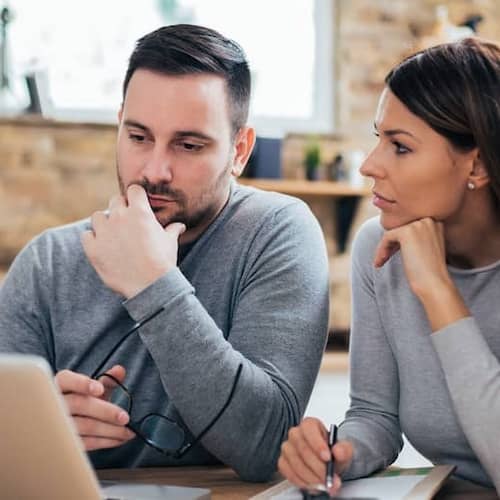 A couple analyzing mortgage rates, possibly comparing options for home financing.
