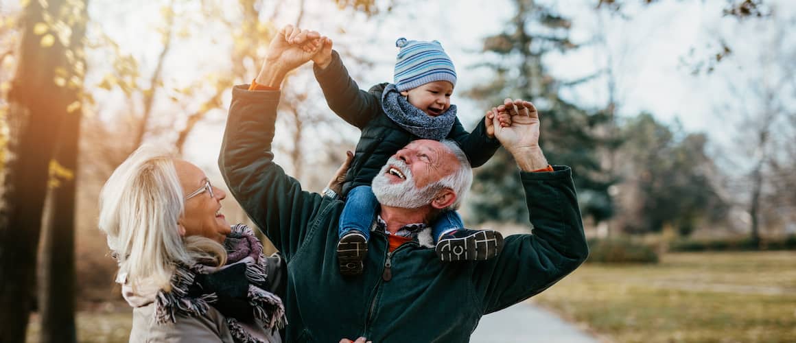 Elderly couple with grandson in park.