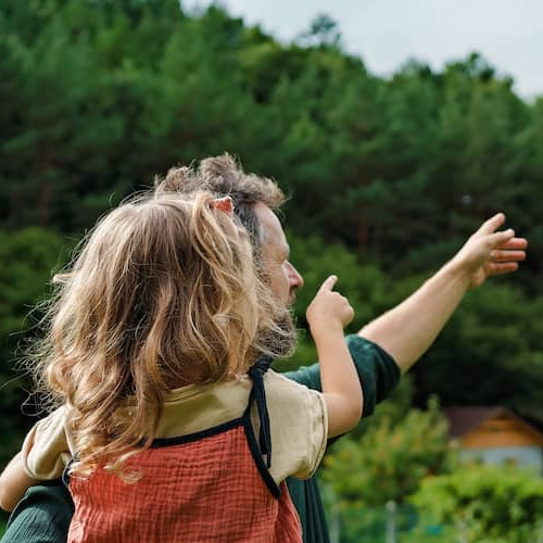 RHB Assets From IGX: A father and daughter pointing at solar panels on a roof.