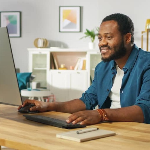 Man sitting at a desk while using a computer.
