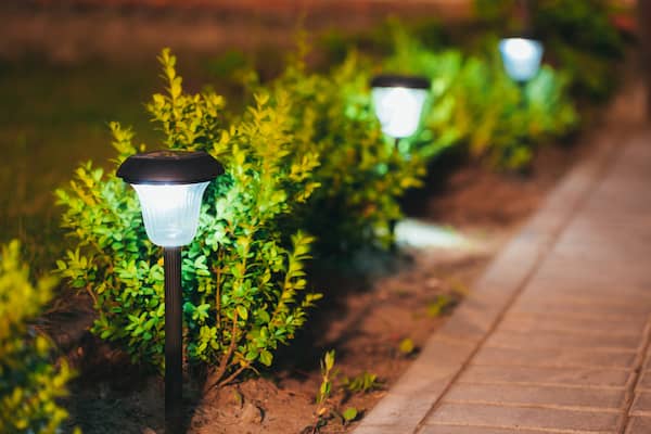 Small garden lights lining a red brick walkway.