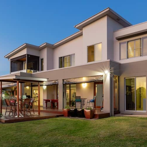 A large modern home with a pool outside.