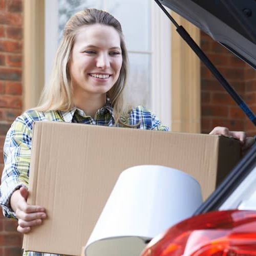 A young woman packing boxes, daughter moving out of parents' home.