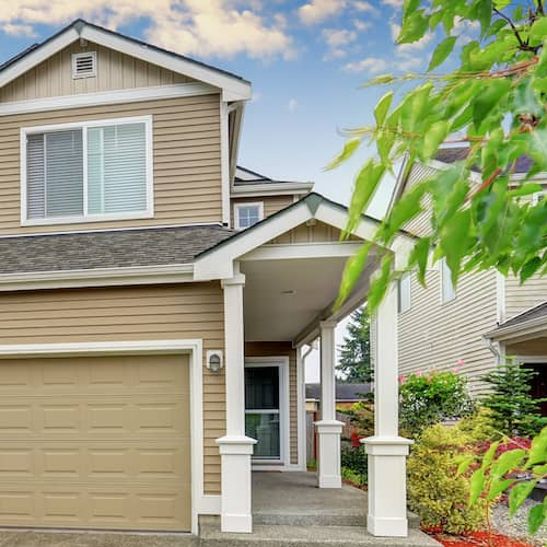 A tan two-story home, showing a two-story house with a tan exterior.