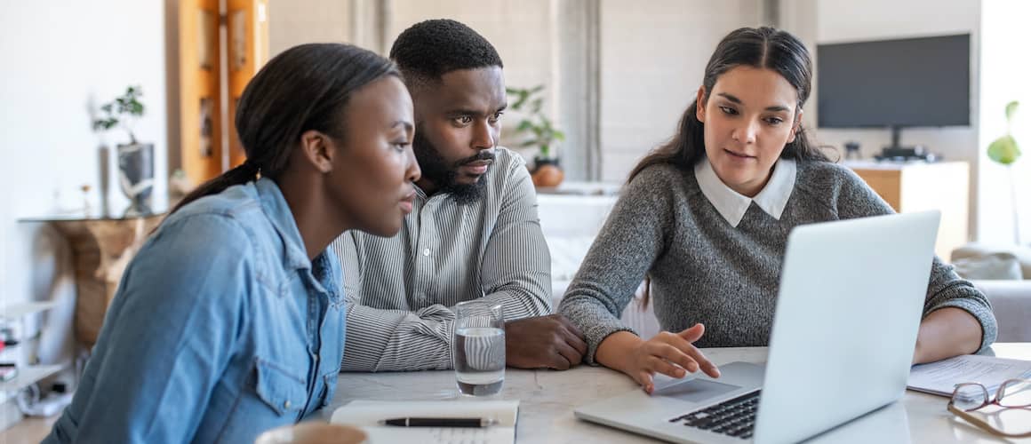 A woman explaining or presenting some real estate option or ideas to a couple.