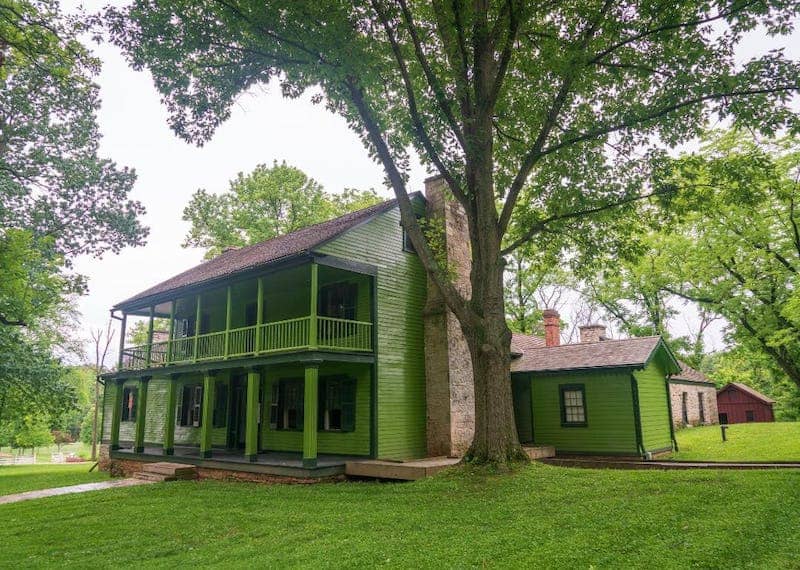 A historic two story green home.