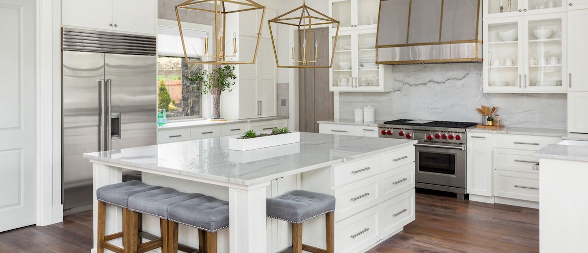 A luxury kitchen with a marble slab backsplash and modern appliances.