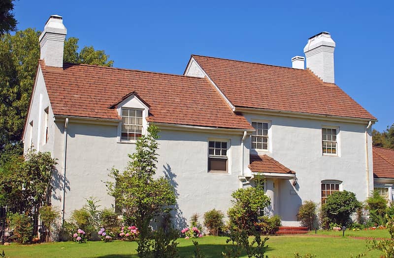 Exterior view of a light gray French country style home.