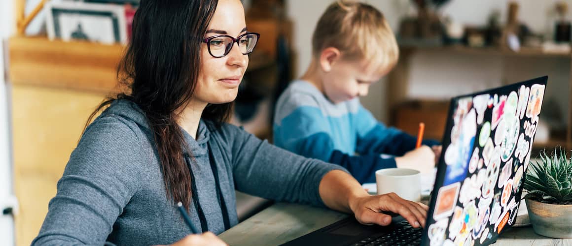 Mother reviewing finances on laptop.