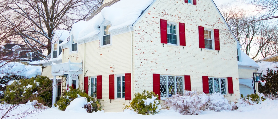 A white brick house in winters under snowy weather.
