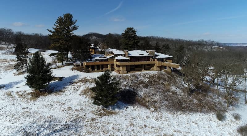 Expansive Prairie-style home with large windows and a low-pitched roof that  blends beautifully into the snow covered surroundings.