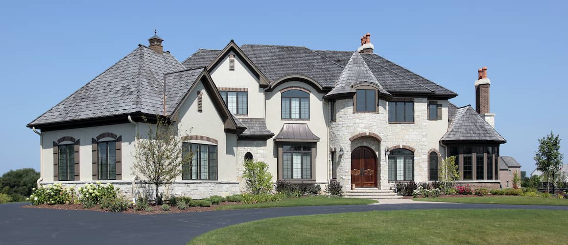 A house exterior with a large front yard and trees.