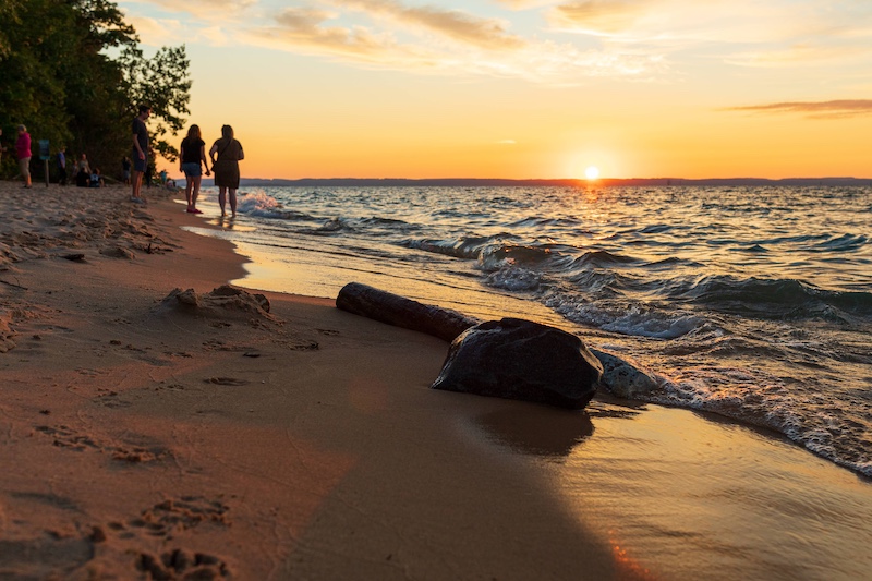 People Walking along the beach on Lake Michigan near Traverse City, Michigan.