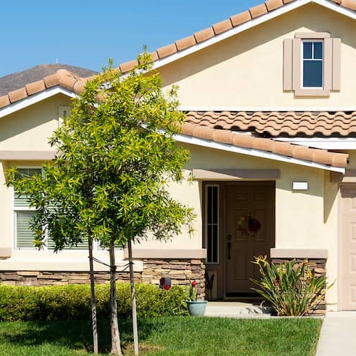 A beige single-family home, potentially showcasing a residential property in a serene neighborhood.