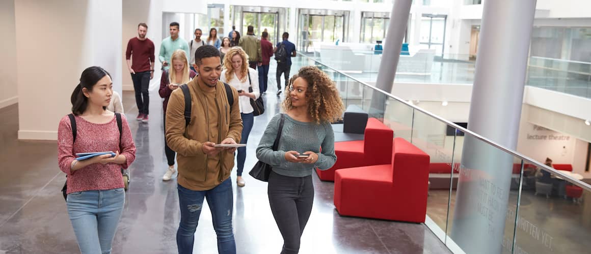 Students walk and talk using mobile devices in university