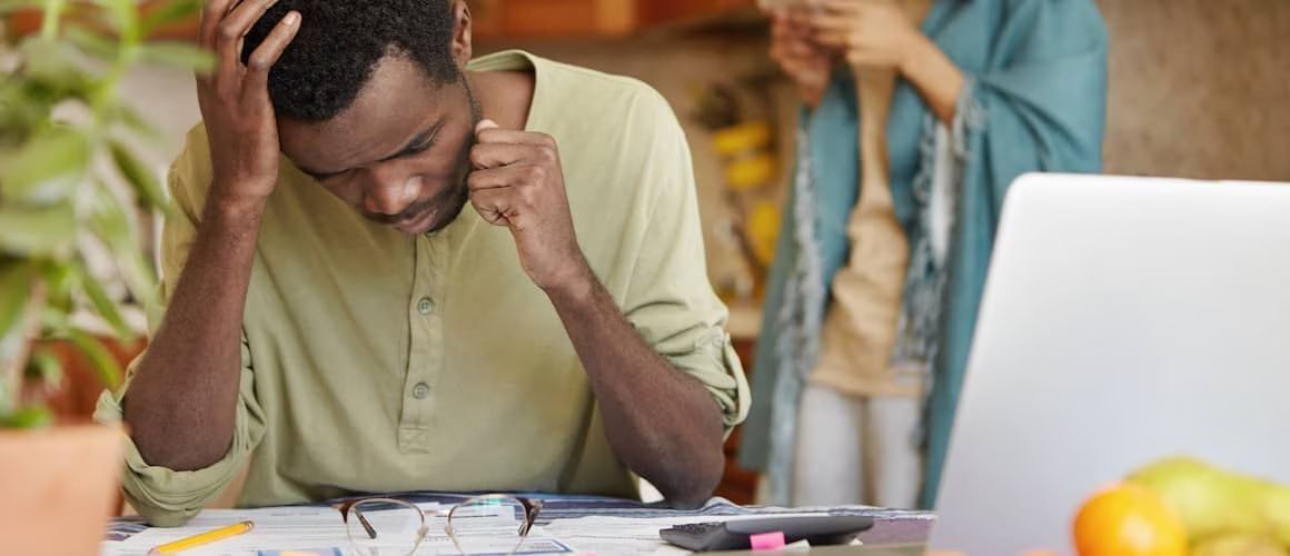 Man frowning as he looks at paperwork.