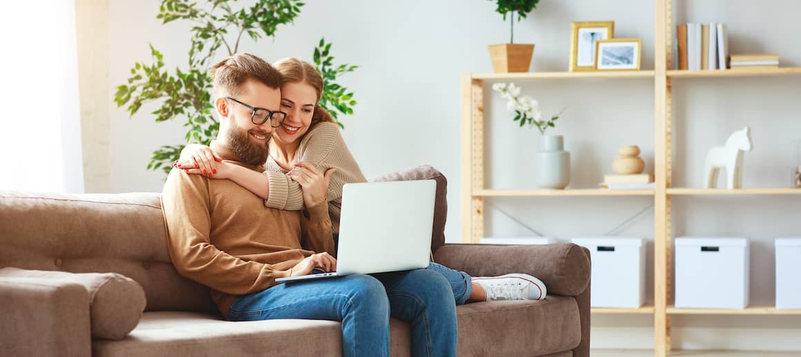 A couple working on a laptop together, potentially related to real estate or financial activities.