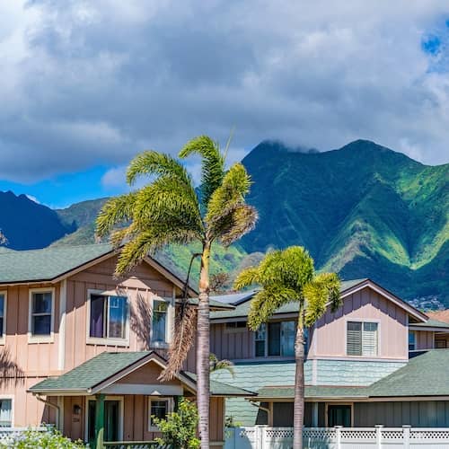 Pastel painted homes in the town of Kahului, Maui, Hawaii with the West Maui Mountains in the background.