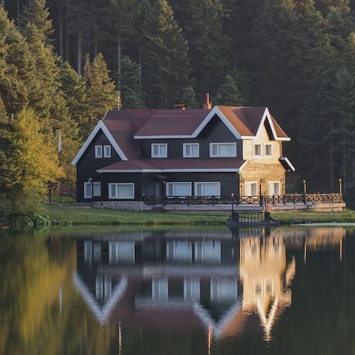 An image depicting a vacant house by a lake, potentially relevant to real estate or property management.