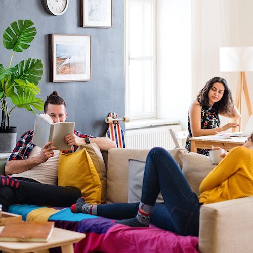 Housemates gathering in a living room, possibly portraying shared living or communal spaces.