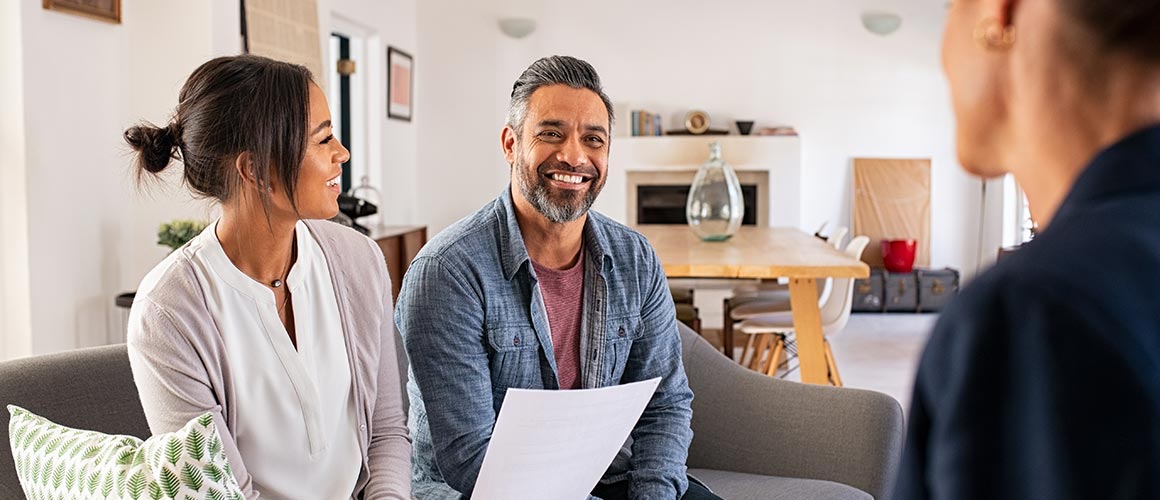 A couple talking with a mortgage lender, potentially in a home buying process.