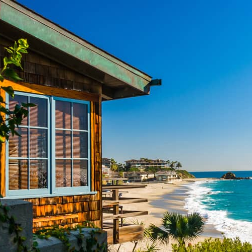 A beach house nestled amidst palm trees, offering a breathtaking view of the ocean.