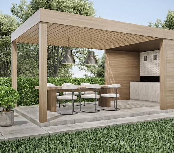 Pergola kitchen in backyard with dining table and seating.