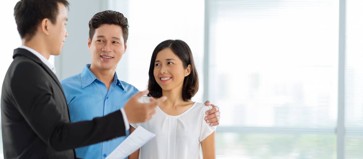 A realtor showing a house to a couple, potentially in a residential setting.