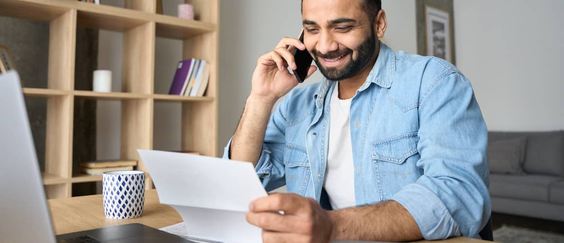 Man on phone holding paper