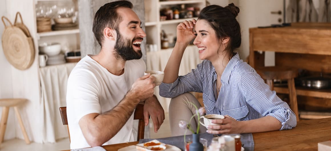 A couple having coffee and smiling.