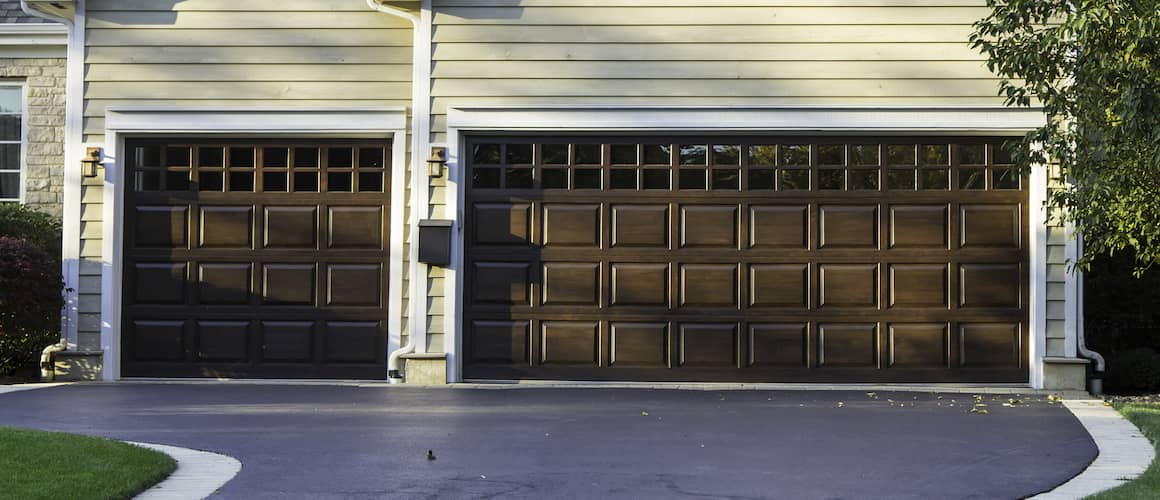 Brown three-car garage doors in suburb home.