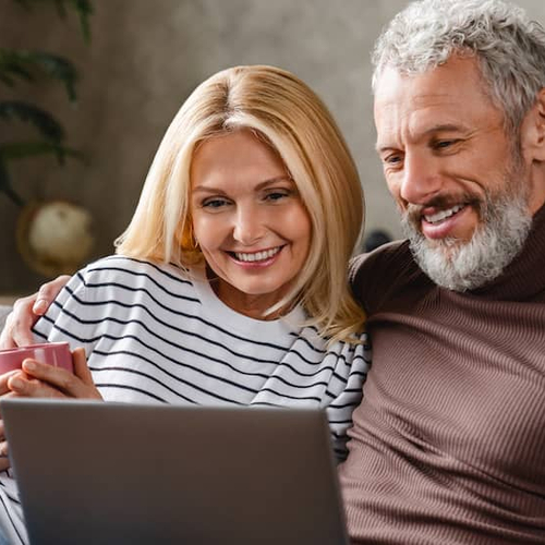 Veteran couple working on a laptop, possibly discussing real estate or financial matters.