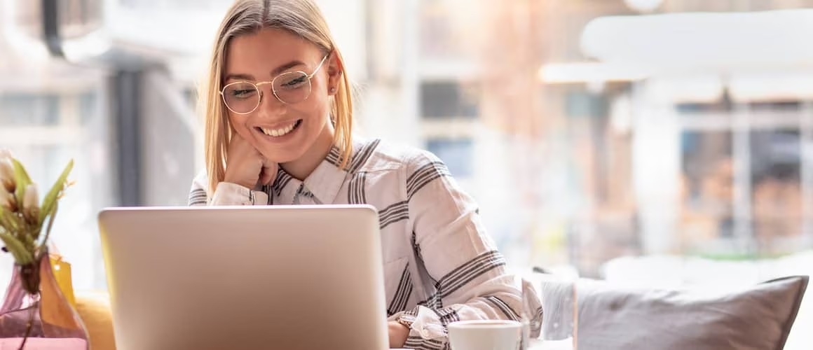 Portrait of young woman using laptop at a coffee shop.