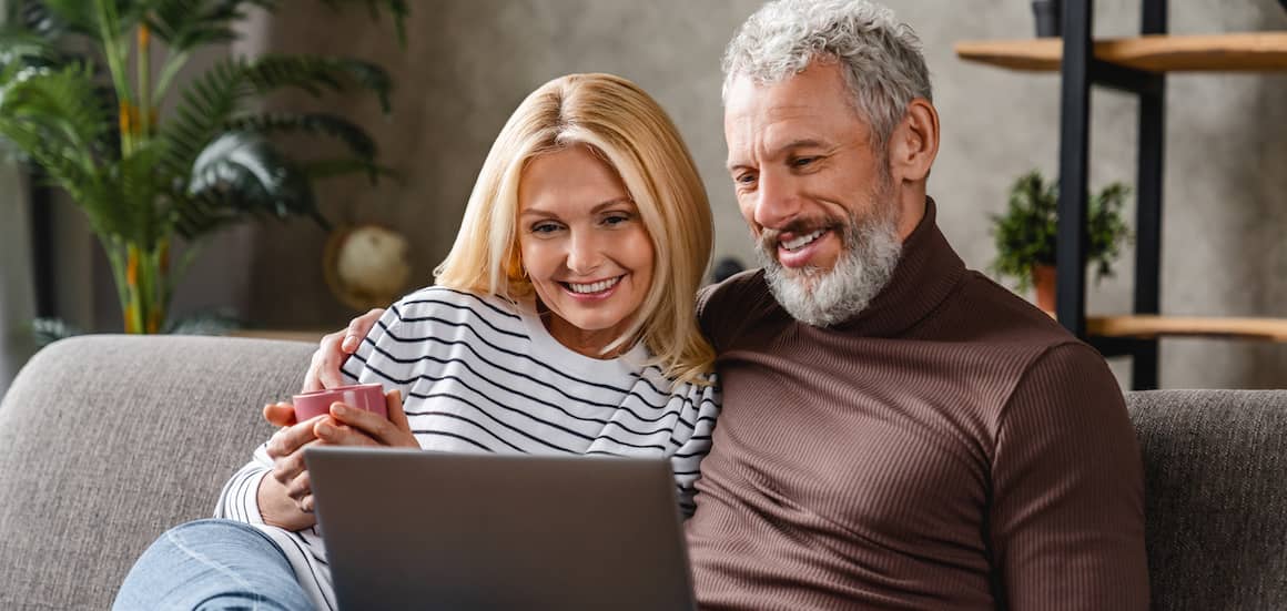 Veteran couple working on a laptop, possibly discussing real estate or financial matters.