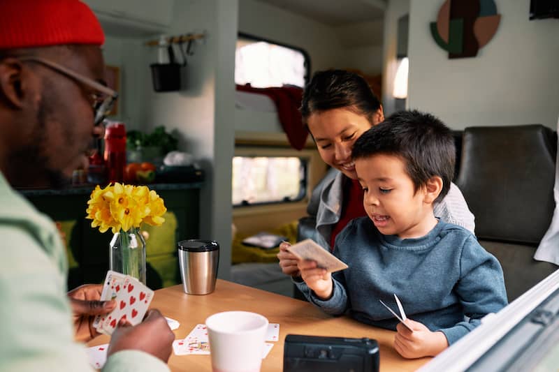 RHB Assets From IGX: Family playing cards in an RV