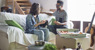 Couple eating pizza moving into their first home