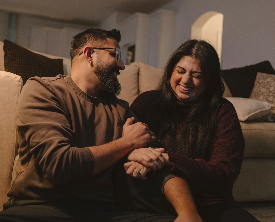 Couple sitting together on a couch at home